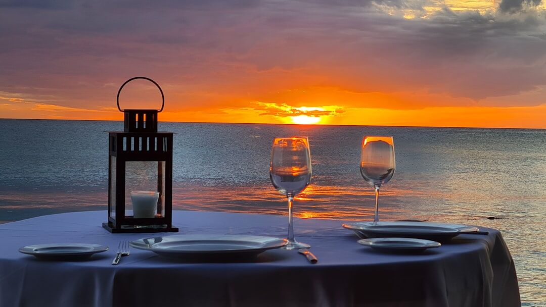 Elegant restaurant table set with candles and wine glasses at sunset